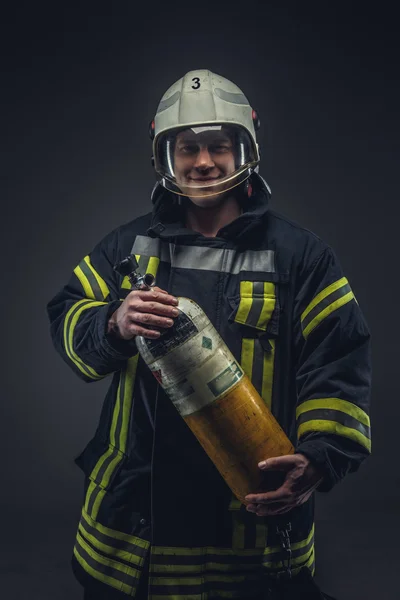 Пожарный удерживает кислородный баллон — стоковое фото
