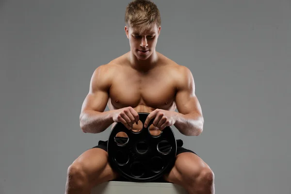 Jovem cara detém pesos barbell . — Fotografia de Stock