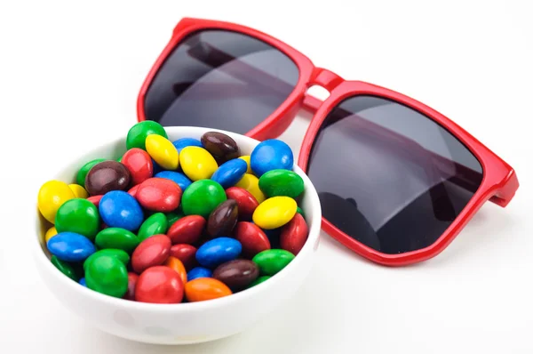 Kırmızı güneş gözlüğü ve renkli şekerler . — Stok fotoğraf