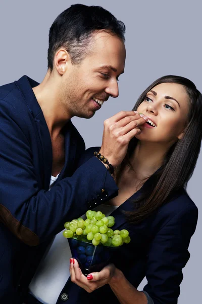 L'homme nourrit une fille avec du raisin vert . — Photo