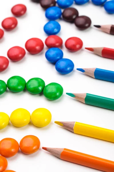 Kleurrijke potloden met snoepjes. — Stockfoto