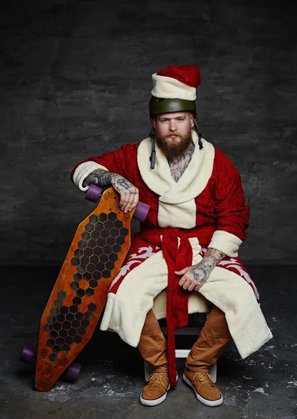 Bearded skater boy in Santa's clothes — Stock Photo, Image