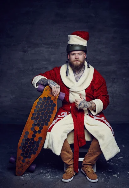 Bearded skater boy in Santa's clothes — Stock Photo, Image