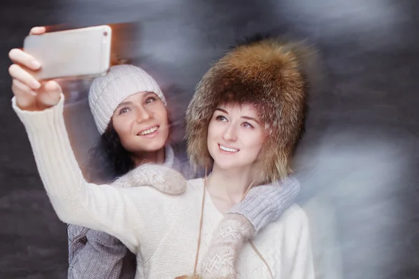 Duas mulheres sorridentes em chapéus de inverno . — Fotografia de Stock