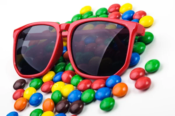 Röda solglasögon och färgglada karameller — Stockfoto