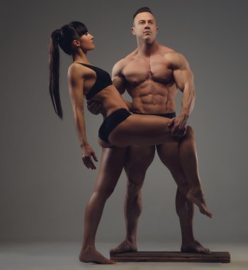 Gömleksiz vücut geliştirmeci ve esmer kadın.