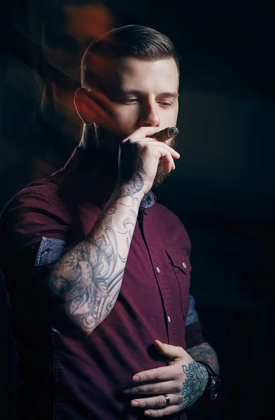 Male with tattoo smokes cigar — Stock Photo, Image