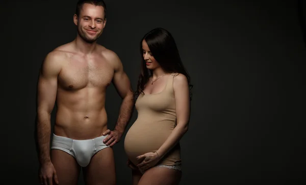 Mulher grávida e homem sem camisa — Fotografia de Stock
