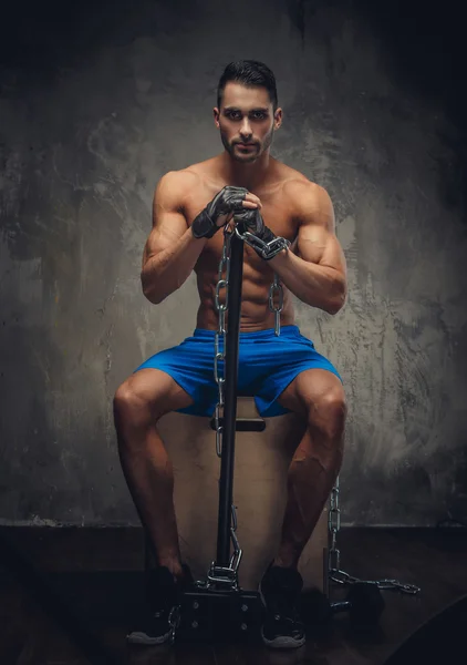 Hombre sin camisa sentado en una caja de madera . —  Fotos de Stock