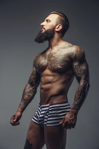 Un hombre con tatuajes en su cuerpo . — Foto de Stock