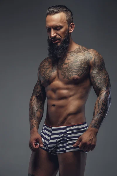 Een man met tattooes op zijn lichaam. — Stockfoto