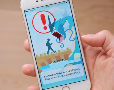 Tallinn, Estonya - 20 Temmuz 2016: Dikkat oyuncu Pokemon Go oynarken çevresi haberdar olmak için tavsiye eder. Yükleme ekranı. Ücretsiz Oynat, Gps tabanlı augmented gerçeklik mobil oyun