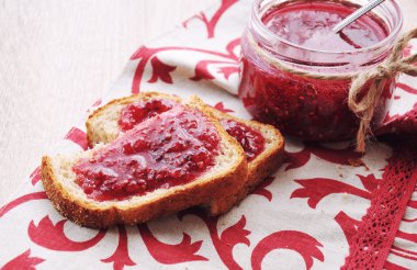 Ev yapımı Frambuaz reçeli kavanoz ve parça ekmek. Kahvaltı konsepti.