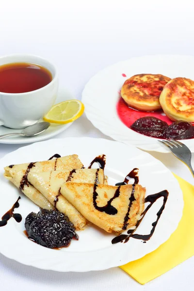 Food of Crepes, cheesecakes with berry sause and cup of tee. — Stock Photo, Image