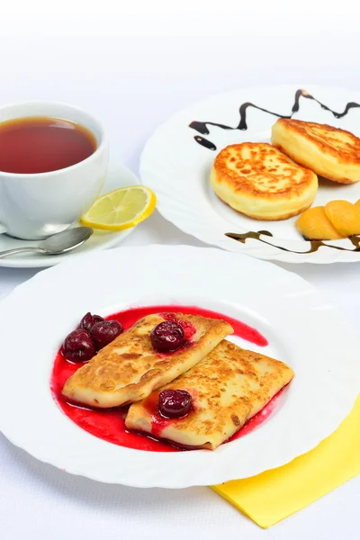 Food of Crepes, cheesecakes with berry sause and cup of tee. — Stock Photo, Image