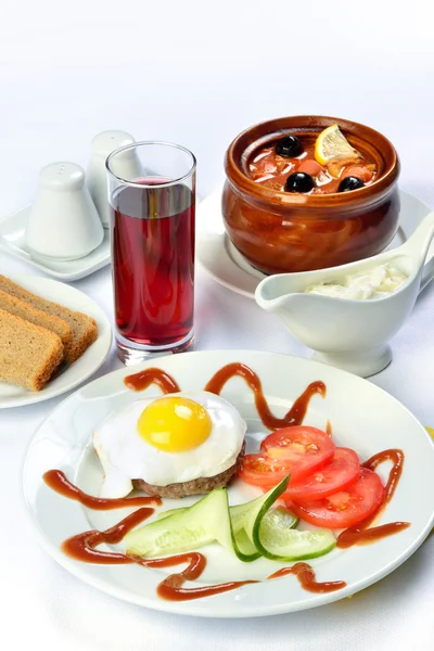 Martwa określonych tabeli z zupy w donice ceramiczne, jajecznica jajko i szklanką soku. — Zdjęcie stockowe