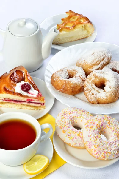 Ainda vida de mesa de treino com tortas de cozimento, rosquinhas, xícara de chá e — Fotografia de Stock