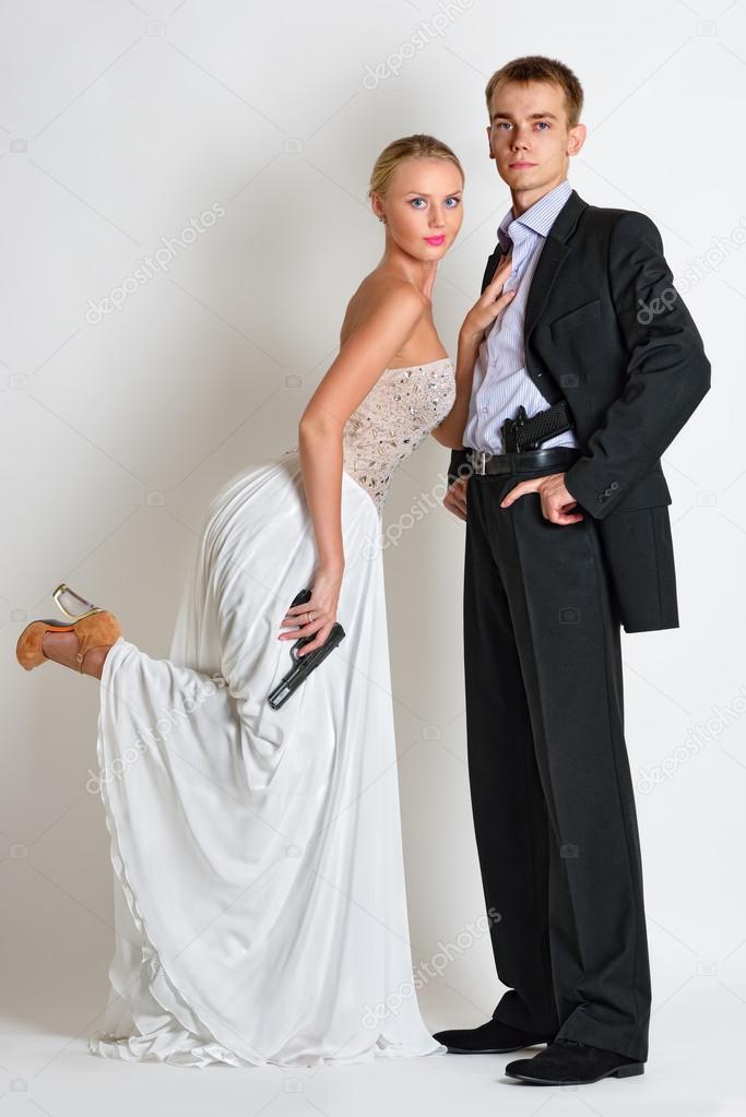 beautiful spy couple in evening dress with a guns.