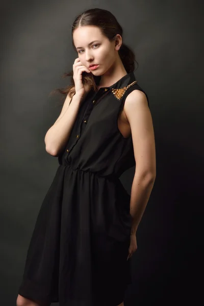 Portret van de mooie vrouw in een zwarte jurk. — Stockfoto
