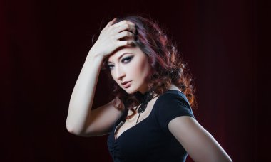 Kırmızı perde arka plan üzerinde siyah elbiseli güzel esmer