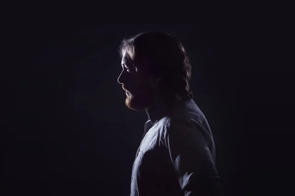 Homem com barba, perfil sobre fundo escuro, a silhueta . — Fotografia de Stock