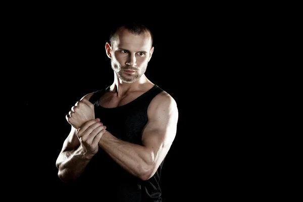 Muskulöser Mann, Hände in der Faust, schwarzer Hintergrund, rechts Platz für Text — Stockfoto