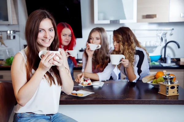 Freunde trinken Tee und Kaffee in der Küche, Porträt der jungen schönen Brünette im Vordergrund, Frau mit weißer Tasse — Stockfoto