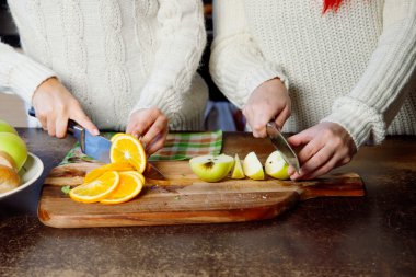 two young girls in the kitchen talking and eating fruit, healthy lifestyle, close-up