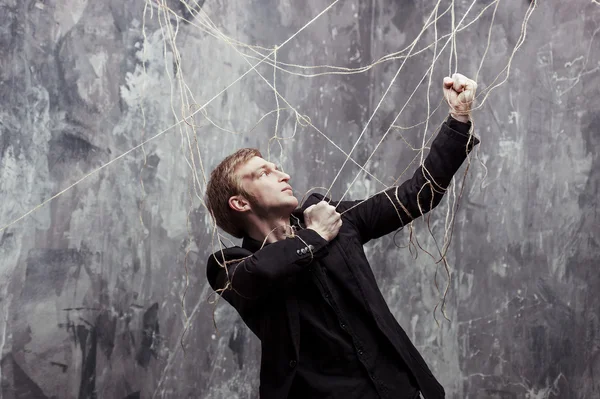 Le jeune homme essaie de briser les chaînes. Concept de manipulation et d'esclavage — Photo