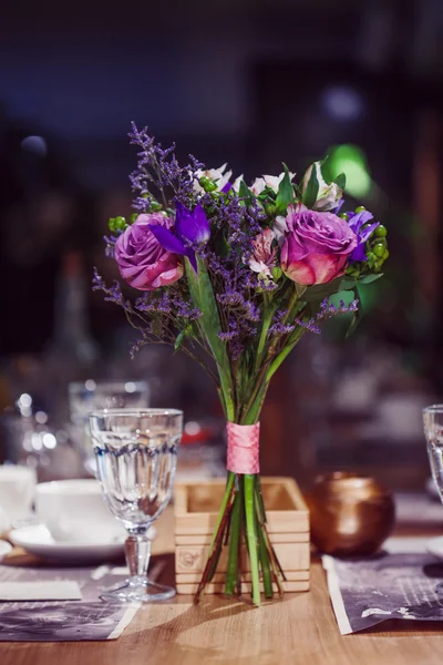 Composição de flores em restaurante, rosas e íris, tons de combinação de roxo — Fotografia de Stock