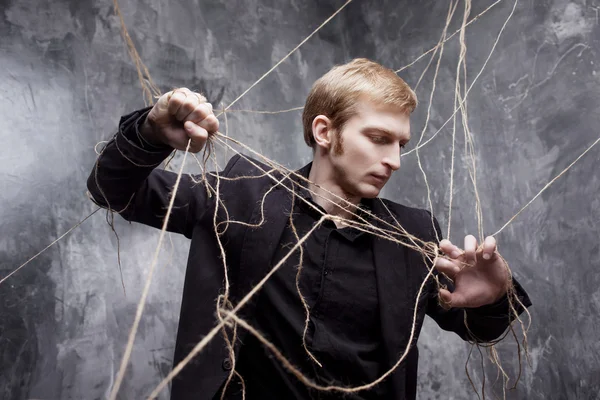 Young man tries to break the shackles. Concept of manipulation and slavery — Stock Photo, Image