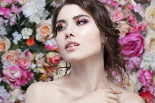 Portrait of  beautiful fashion girl, sweet, sensual. Beautiful makeup and messy romantic hairstyle. Flowers background. Green eyes. — Stock Photo, Image