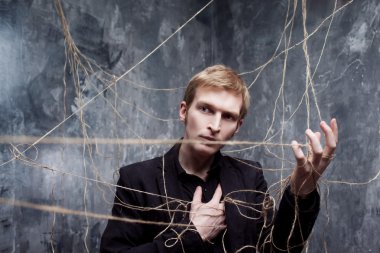 Elim kolum bağlı. Siyah elbiseli genç adam web üzerinde yakalandı. Kavramı manipülasyon ve kölelik