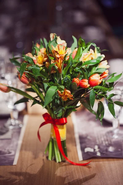 Composizione floreale in ristorante, piccole rose rosse e iris viola, combinazione di più colori — Foto Stock