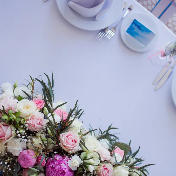 Blomsterarrangemang på bordet. Blommor och vita dukar, bröllop, rosor, pioner. Ovanifrån, plats för text. — Stockfoto