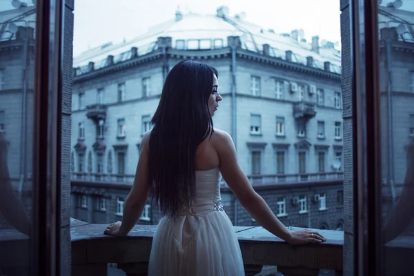 El retrato de la mujer joven hermosa en el balcón, la ciudad de tarde —  Fotos de Stock