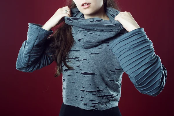 Trying to free neck from large collar. Young beautiful brunette girl portrait in Studio pink background — Stock Photo, Image