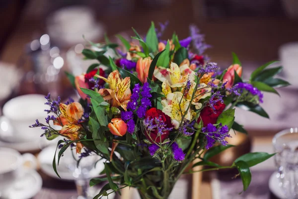 Composición de flores en restaurante, rosas e iris, tonos combinados de púrpura — Foto de Stock