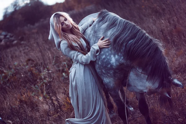 Belleza rubia con caballo en el campo, efecto de tonificación — Foto de Stock