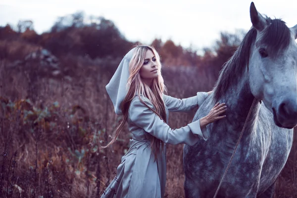 Beauty blondie with horse in the field, effect of toning — Stock Photo, Image