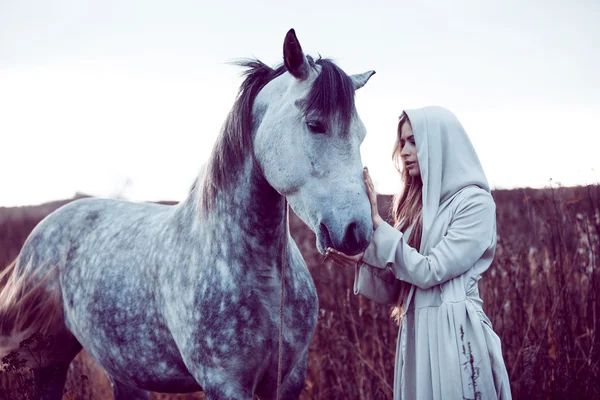 Meisje in de hooded cloak met paard, effect van toning — Stockfoto