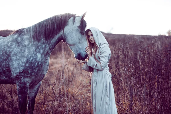 Fille dans le manteau à capuche avec cheval, effet de tonification — Photo