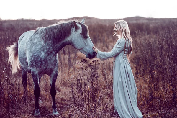 Chica en la capa encapuchada con caballo, efecto de tonificación —  Fotos de Stock