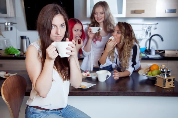 Vrienden drinken thee en koffie in de keuken, portret van jonge mooie brunette in de voorgrond, vrouw met witte kop — Stockfoto