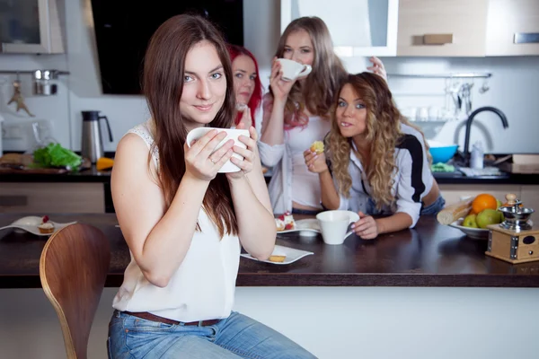 Amigos bebem chá e café na cozinha, retrato de jovem bela morena em primeiro plano, mulher com copo branco — Fotografia de Stock