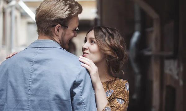 Pareja joven enamorada al aire libre. El hombre abraza a la mujer. La chica mira por encima del hombro de un compañero —  Fotos de Stock