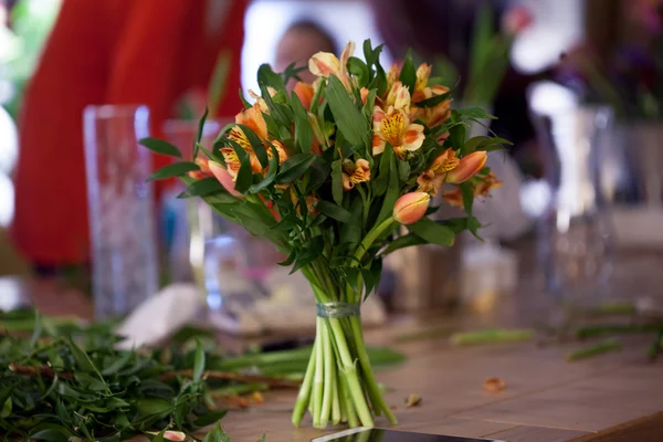 Kytice na stole v květinové Studio — Stock fotografie