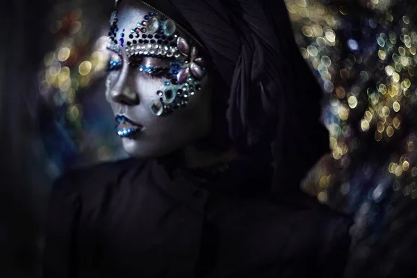 Young beautiful girl in black makeup with rhinestone, dark background, blur effect — Stock Photo, Image