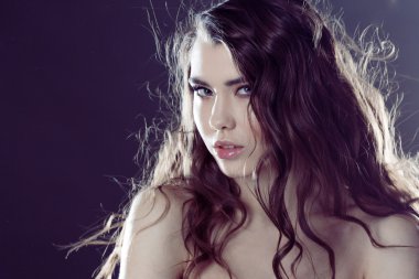 Uzun dalgalı saçlı güzel genç esmer kız. Kıvırcık saç modeli.