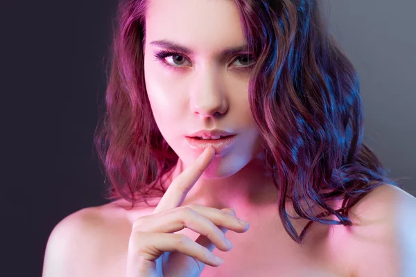 Aantrekkelijke jonge brunette persen een vinger aan zijn lippen. De toning effect. — Stockfoto